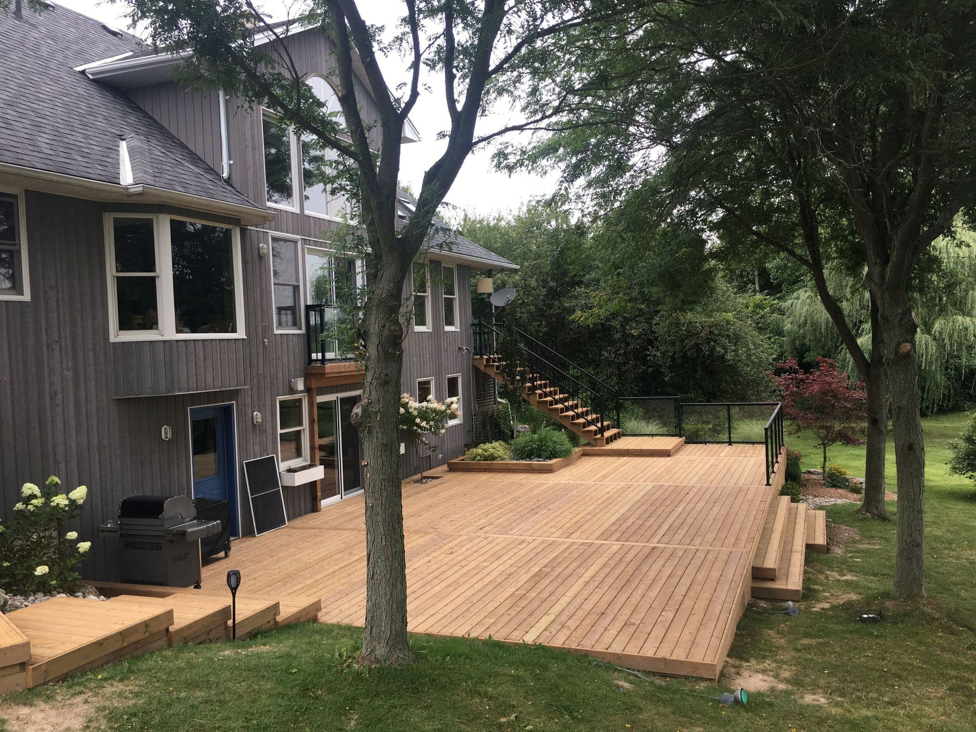 Large wood deck with broad stairs leading to the yard